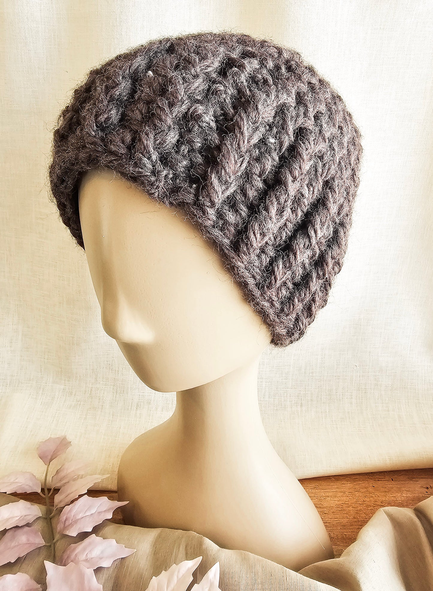 Knitted gray beanie on a mannequin head against a neutral background