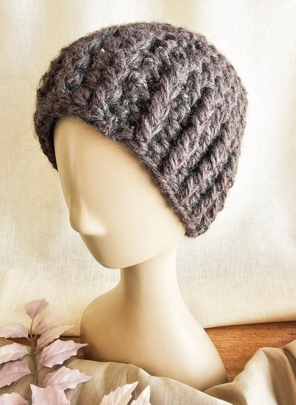 Knitted gray beanie on a mannequin head against a neutral background