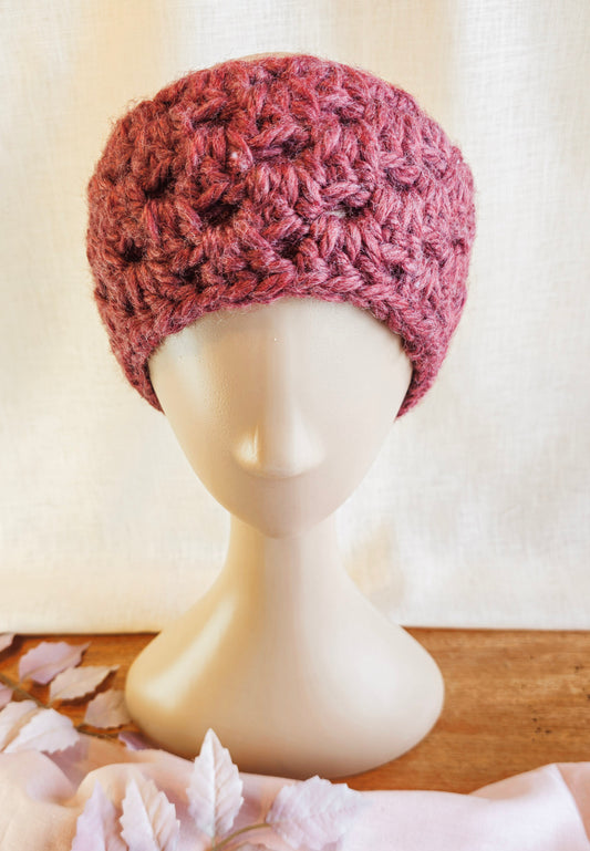 Pink knitted headband on a mannequin head with a light background