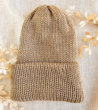 Knitted beanie on a textured fabric background with floral elements