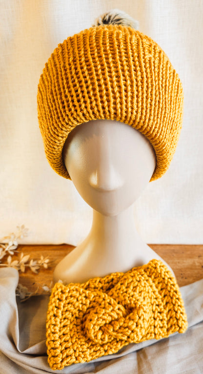 Mustard yellow knitted hat and headband on a mannequin against a neutral background
