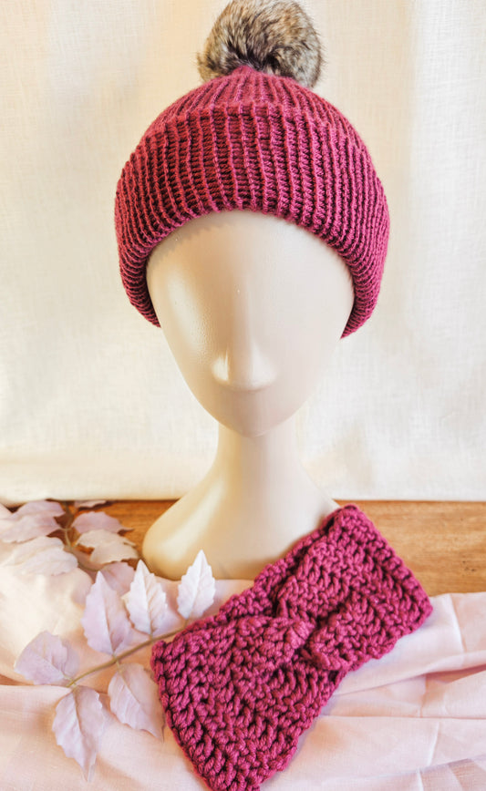 Knitted pink beanie with pom-pom and matching headband on a mannequin head.