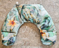 Hot and Cold neck pack with a tropical floral and leaf pattern in shades of green, beige, and orange, laid flat on a textured stone surface.
