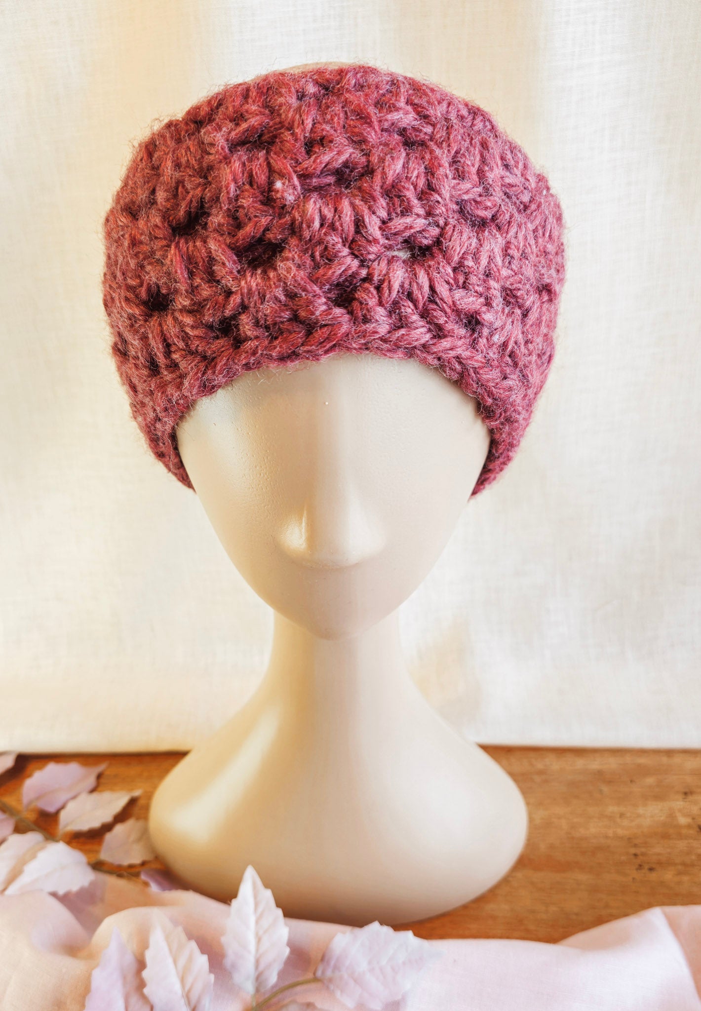 Pink knitted headband on a mannequin head with a light background