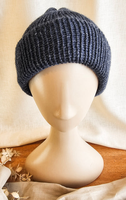 Dark gray knitted beanie on a mannequin head with a neutral background