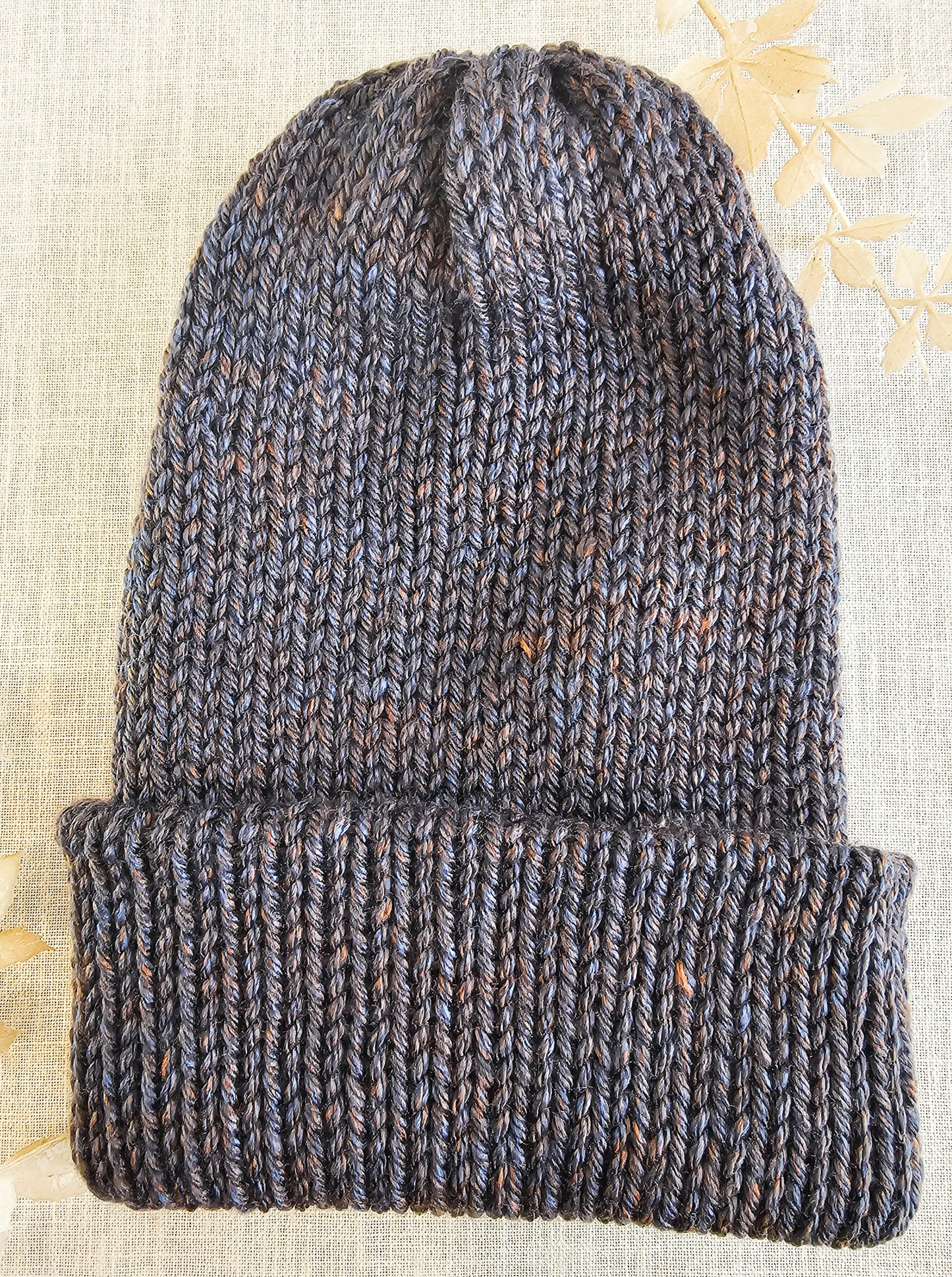 Knitted beanie on a textured fabric background