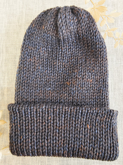 Knitted beanie on a textured fabric background