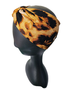 Leopard print headband on a black mannequin head against a white background