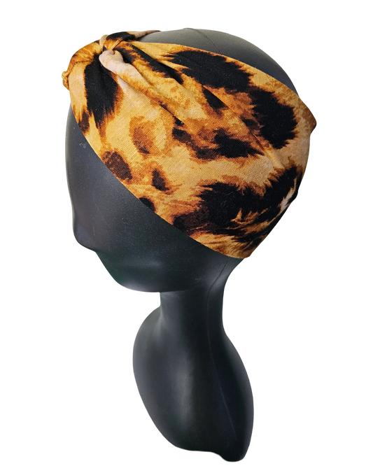 Leopard print headband on a black mannequin head against a white background