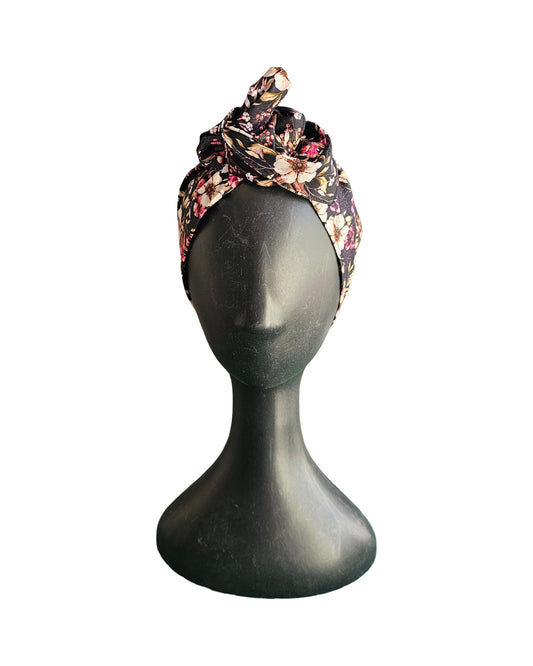 Floral patterned headband on a mannequin head against a white background