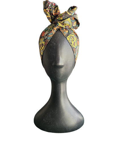 Colorful patterned headscarf on a mannequin head against a white background