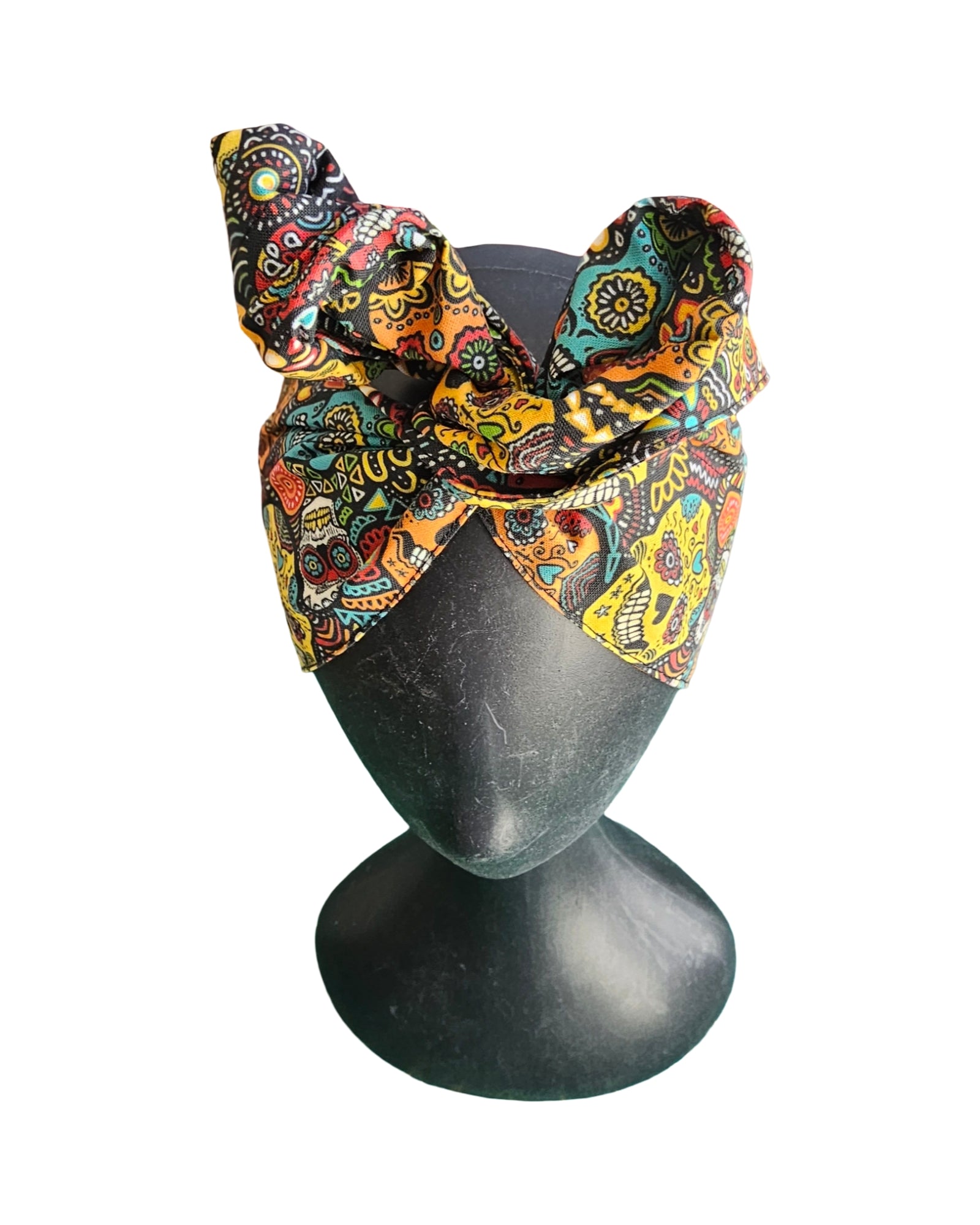 Colorful patterned headscarf on a mannequin head against a white background