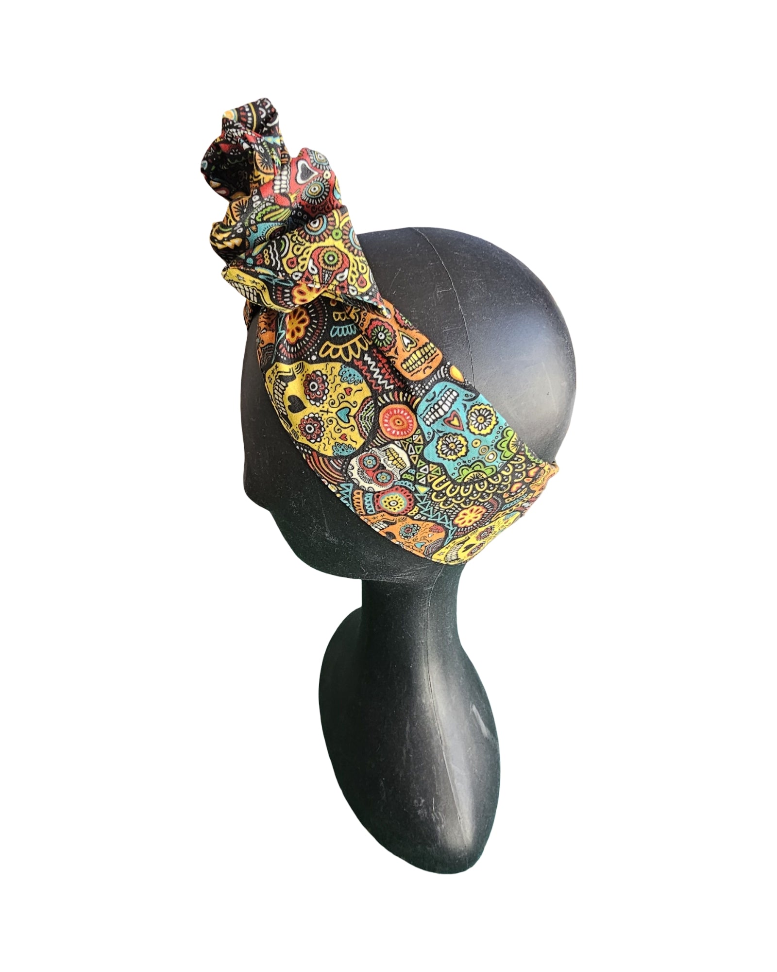 Colorful patterned headband on a black mannequin head against a white background