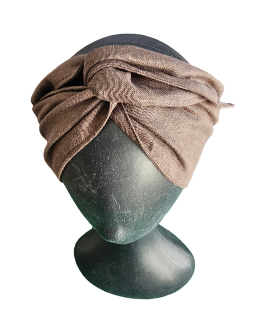 Brown turban on a mannequin head against a white background