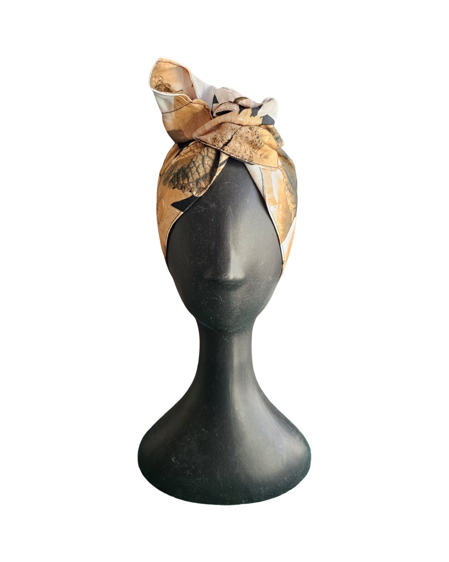Mannequin head wearing a patterned headscarf on a white background