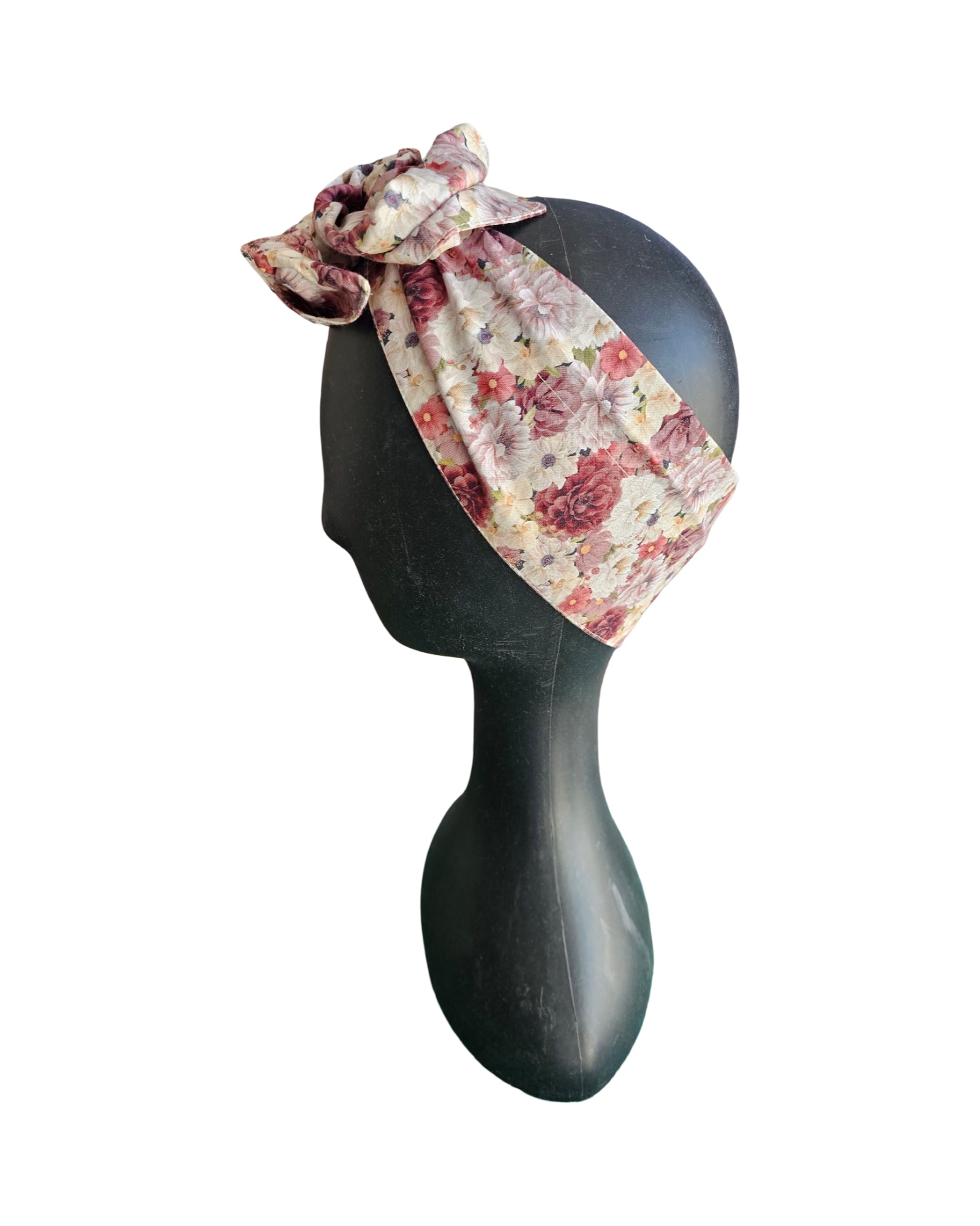 Floral headband on a black mannequin head against a white background