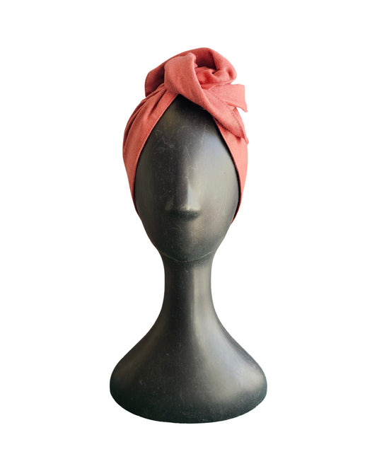 Coral headscarf on a mannequin head against a white background