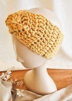 Knitted beige headband on a mannequin head with a white background