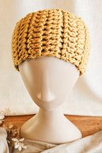 Knitted beige headband on a mannequin head against a neutral background