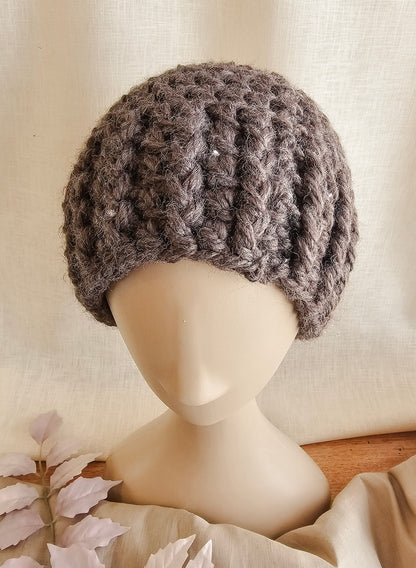 Knitted gray beanie on a mannequin head against a neutral background