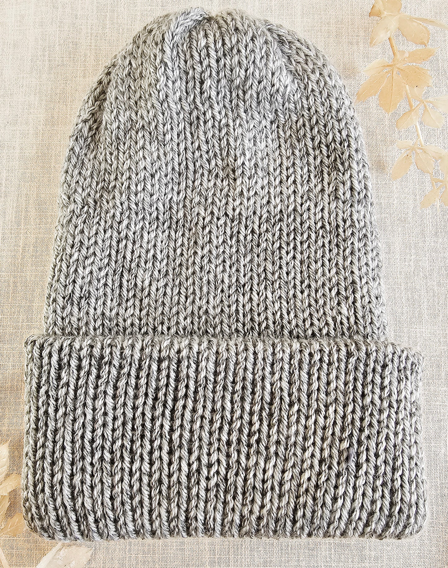 Knitted beanie on a textured beige background