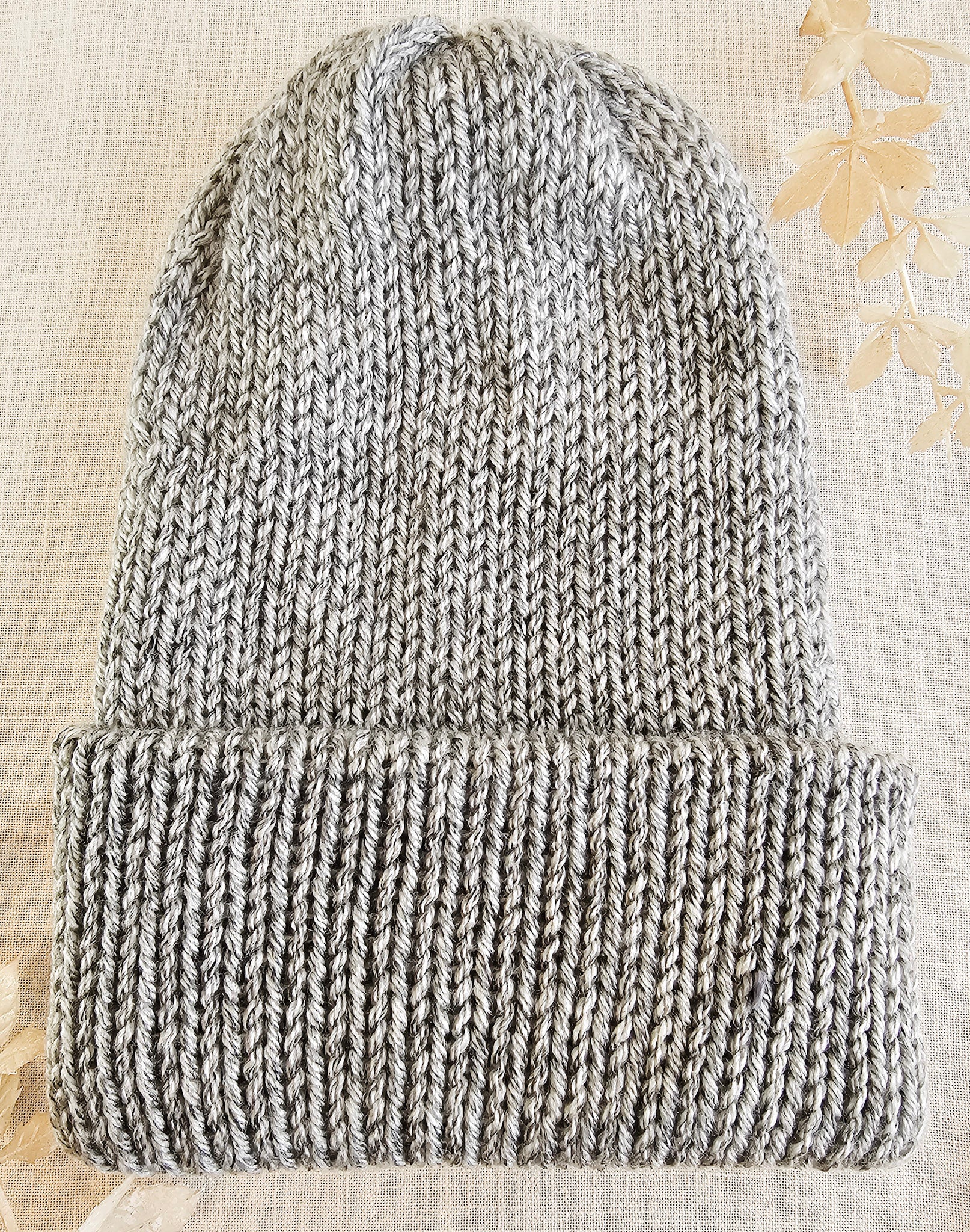 Knitted beanie on a textured beige background