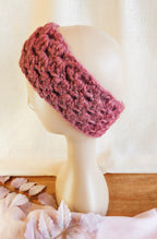 Pink knitted headband on a mannequin head against a white background