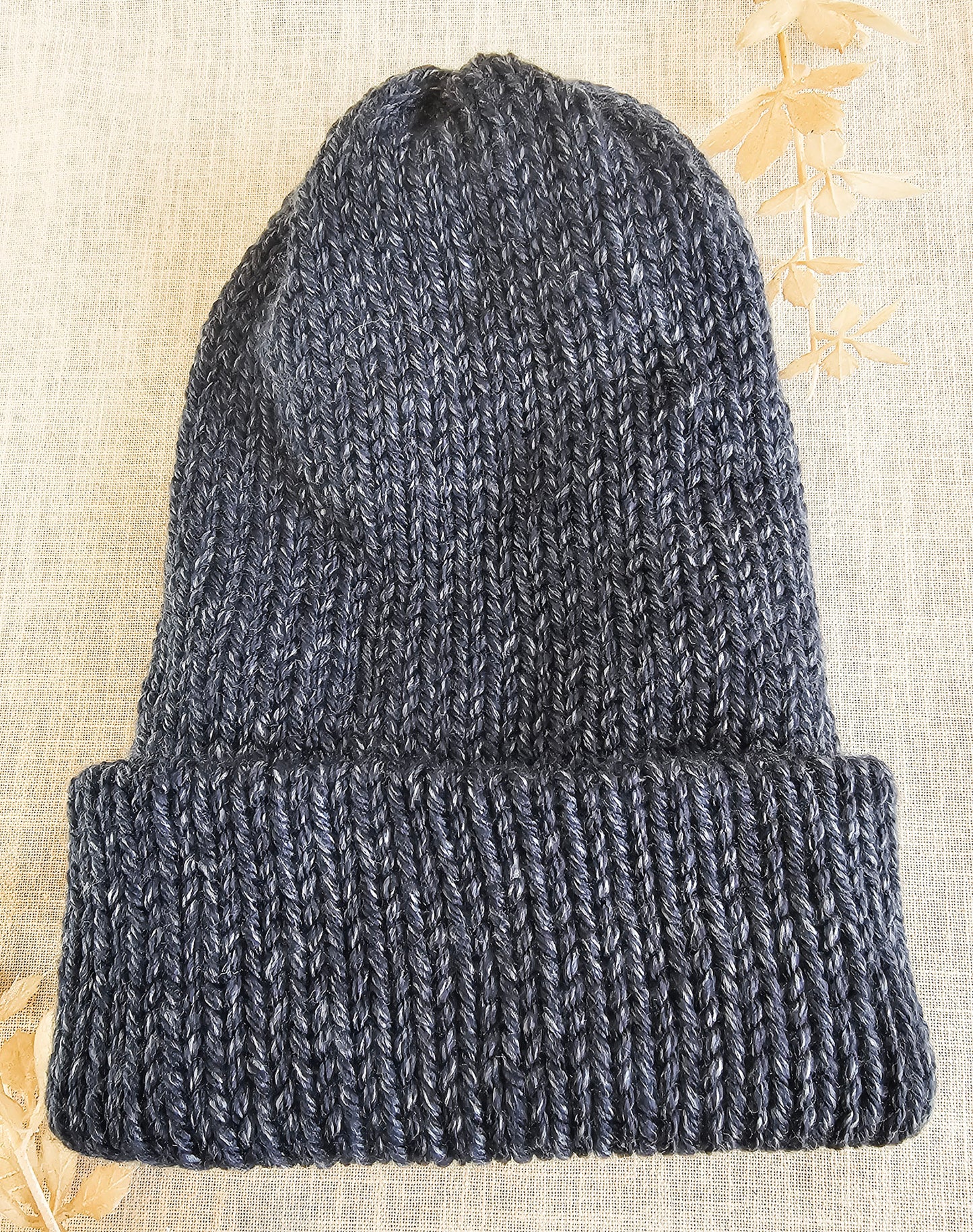 Knitted beanie on a textured beige background
