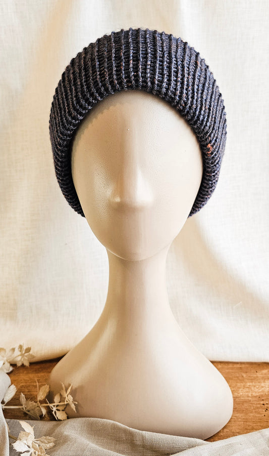 Knitted headband on a mannequin head with a neutral background