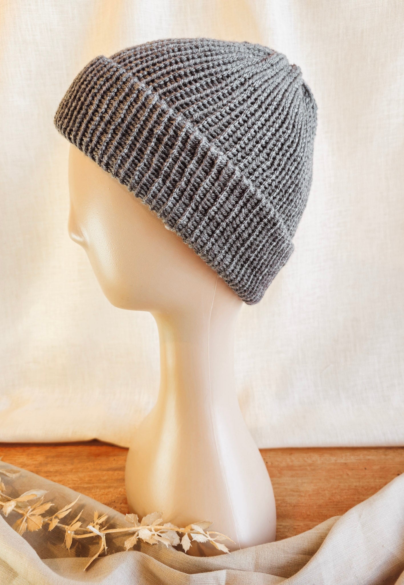 Gray knit beanie on a mannequin head with a neutral background