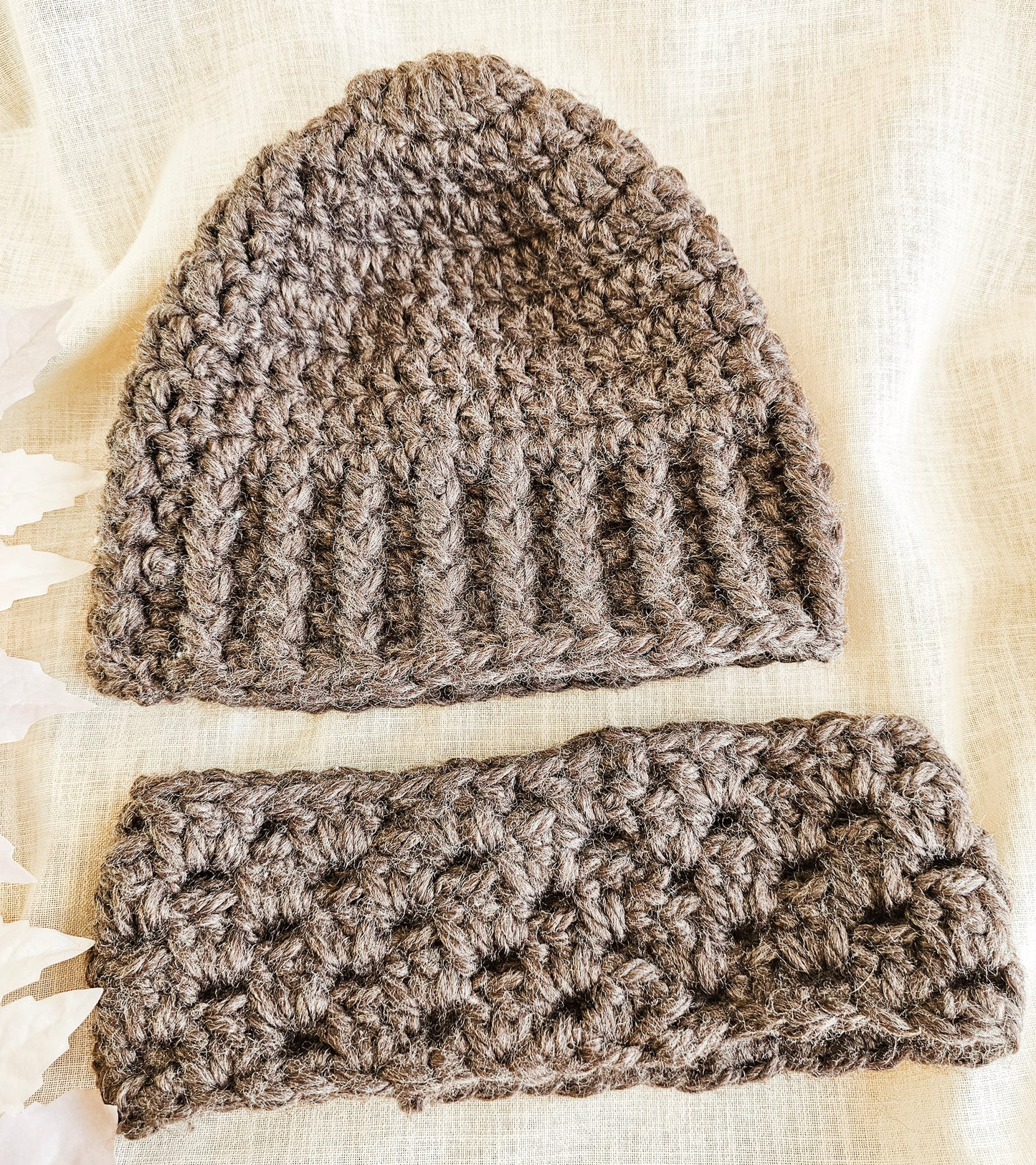 Brown crochet beanie and matching headband on a light fabric background