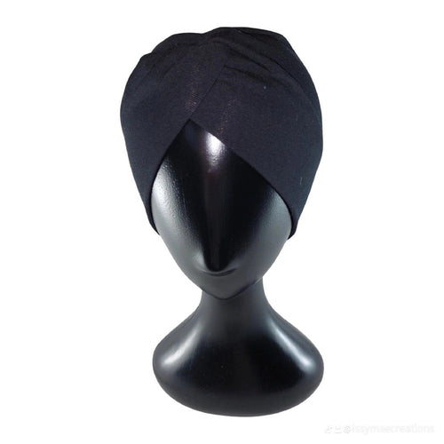 Black turban on a mannequin head against a white background