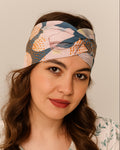 Woman wearing a colorful patterned Knotted headband against a neutral background