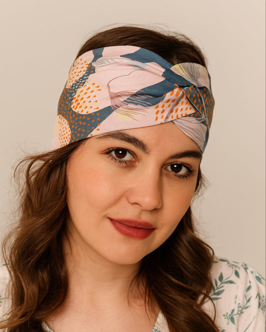 Woman wearing a colorful patterned headband against a neutral background