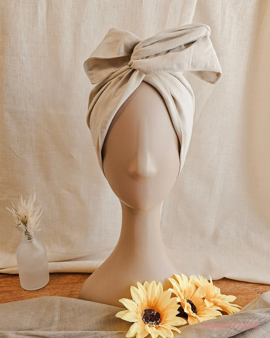 mannequin head with cream wire head wrap, with sundlowers and linen back drop
