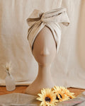 mannequin head with cream wire head wrap, with sundlowers and linen back drop