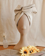 mannequin head with cream wire head wrap, with sundlowers and linen back drop