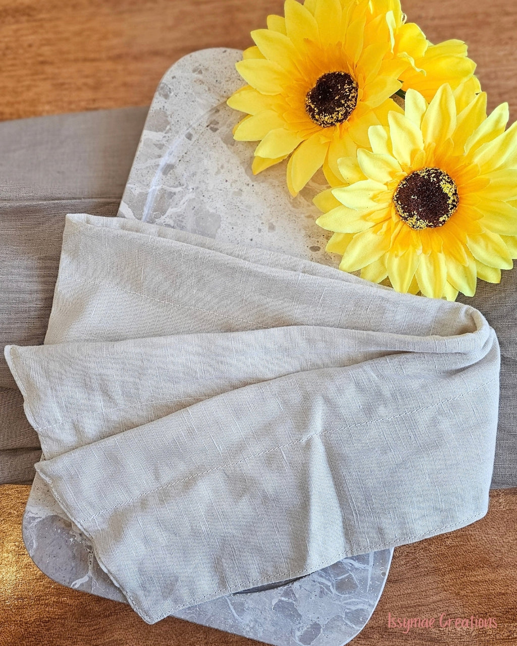 Flat View of a cream wire headwrap with sunflowers on wooden back drop