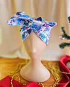 Christmas wire head wrap with a large top bow, featuring blue and purple gnomes and white snowflakes.