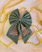 Green Hair Bow with embroidery on a cream back ground with gold beaded chain