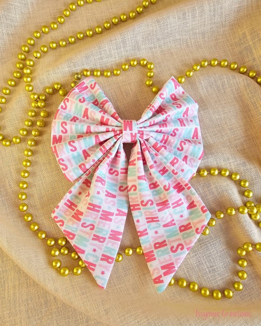 Christmas pattern hair bow on cream and gold beads background