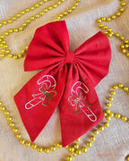 Red Christmas Hair Bow with embroidery on a cream background with gold beaded chain