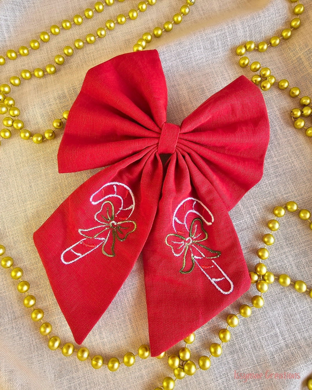 Red Christmas Hair Bow with embroidery on a cream background with gold beaded chain