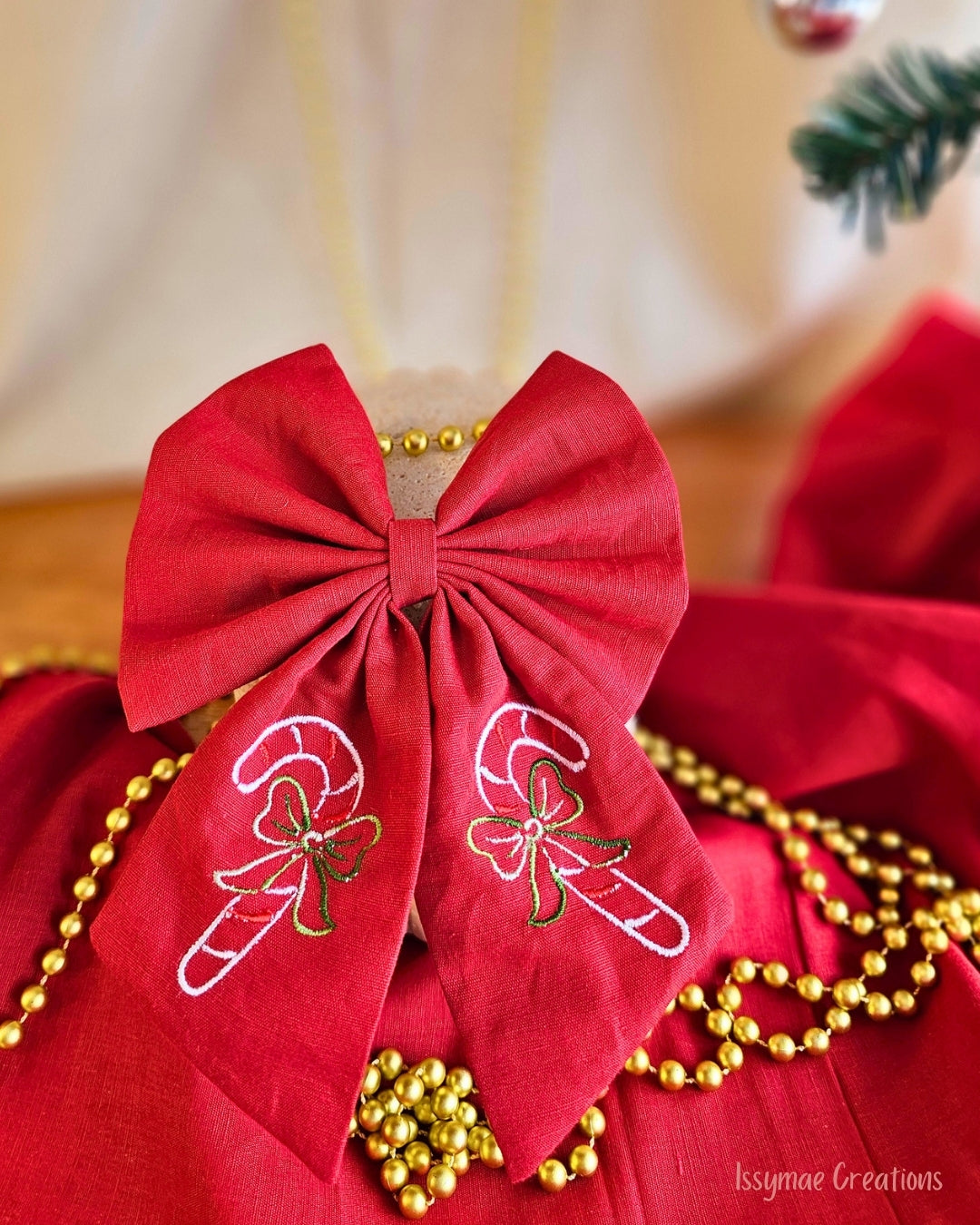 Red Hair Bow with candy can embroidery with a cream and red back ground with gold chain