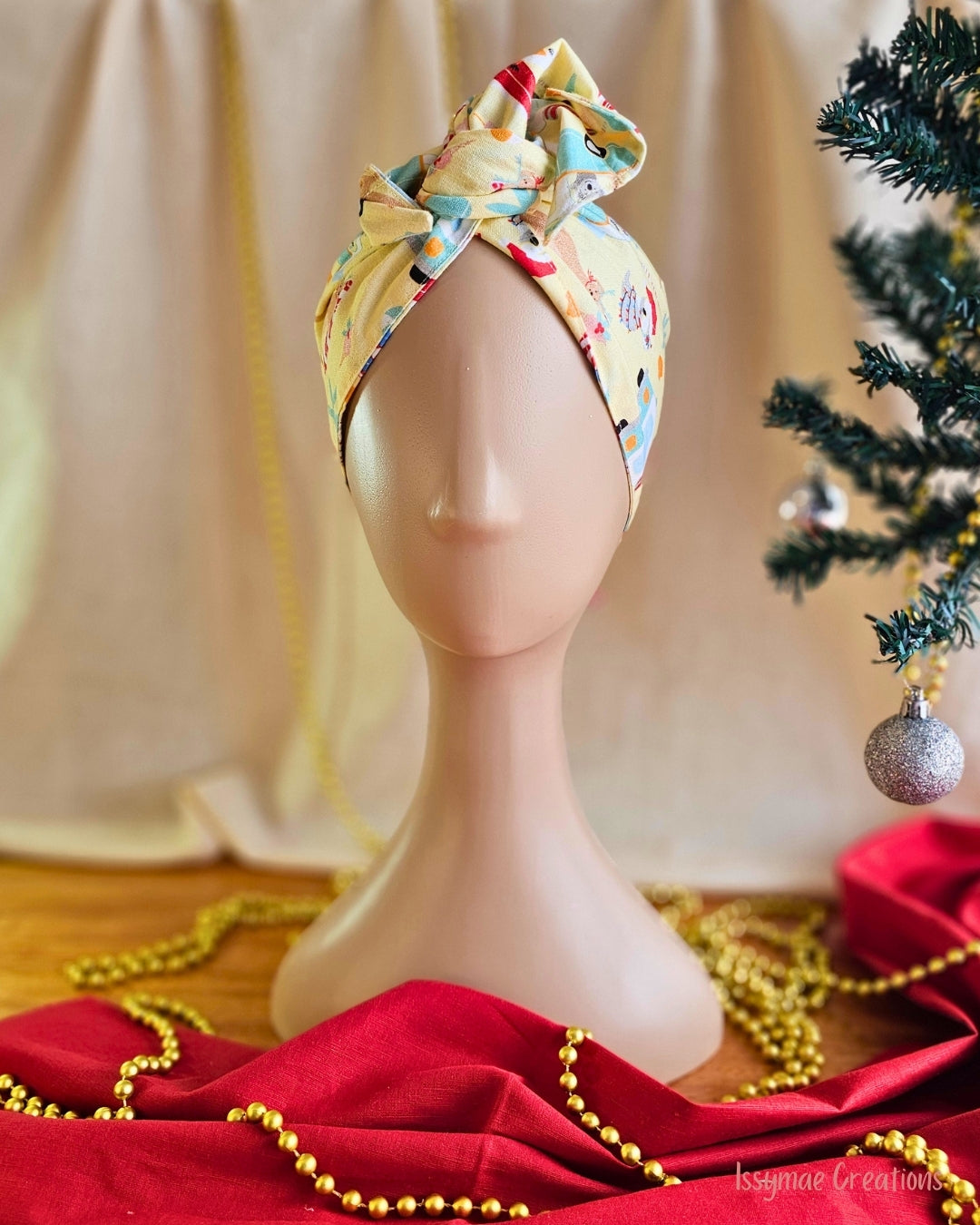 Koala Clause Christmas wire head wrap in pale yellow, styled with a twisted top knot on a mannequin.
