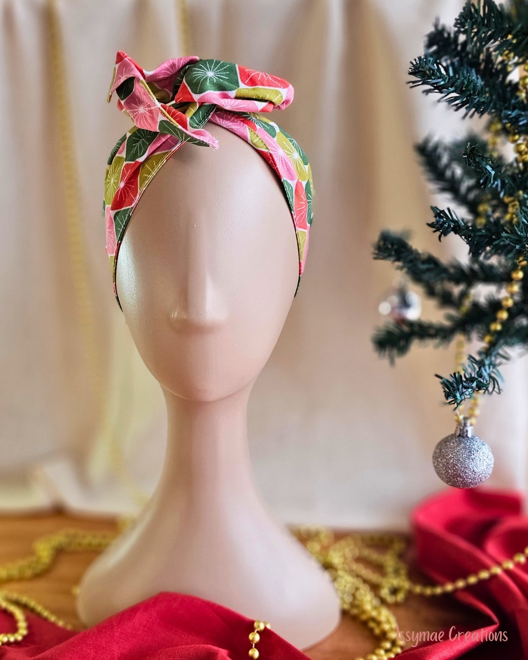 Merry Starburst wire head wrap with a colourful retro starburst print, styled in a top knot on a mannequin.