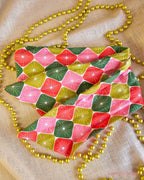 Merry Starburst wire head wrap laid flat, showing pink, red and green retro starbursts, surrounded by gold beads.