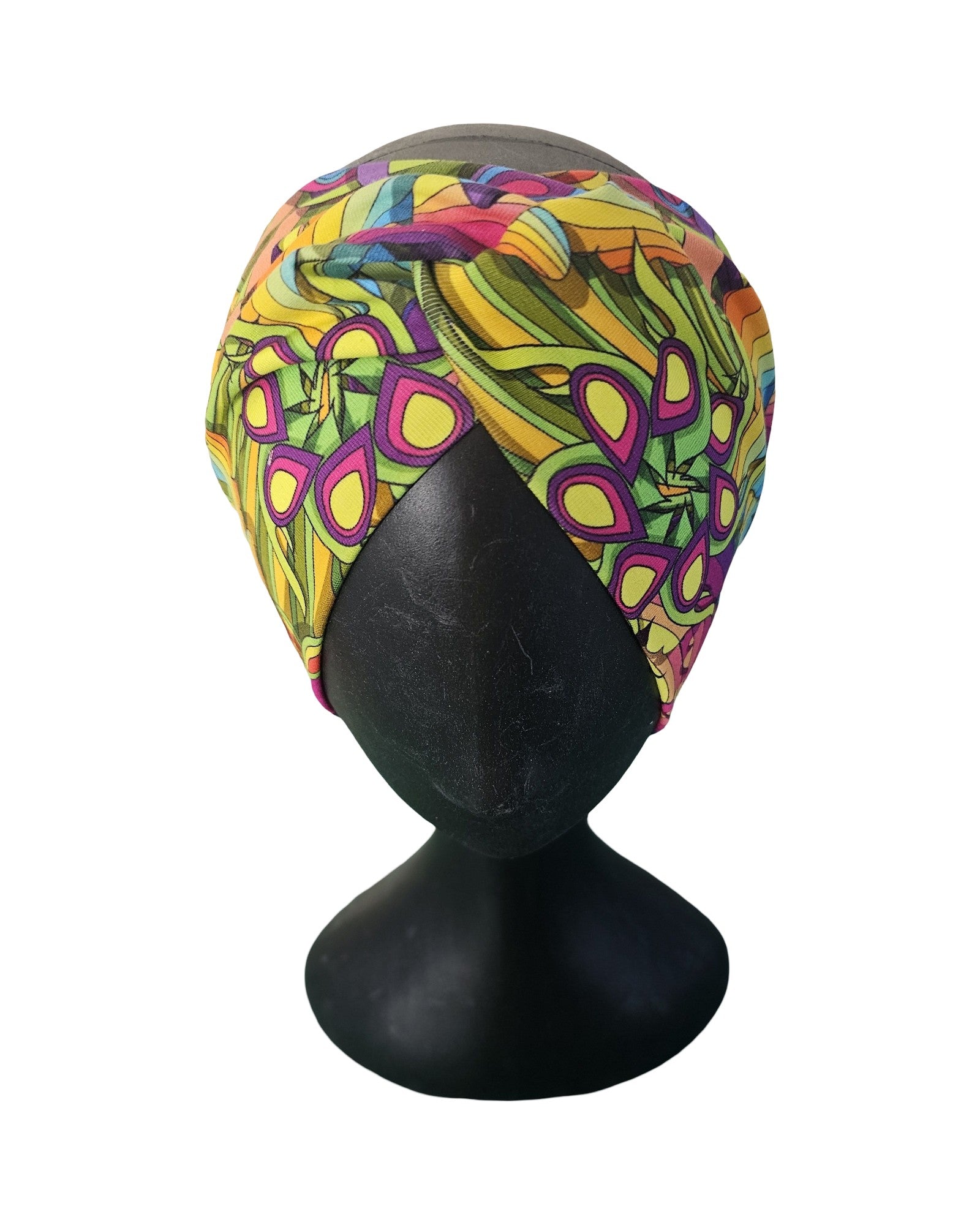 Colorful patterned headscarf on a black mannequin head against a white background