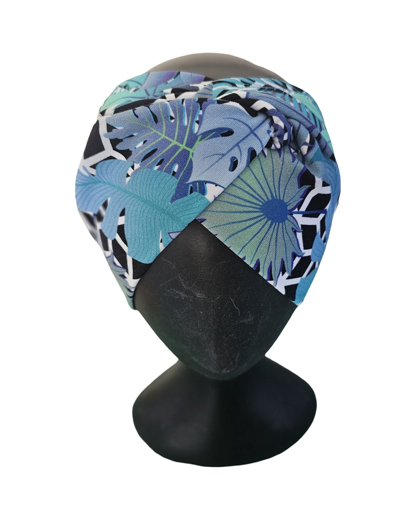 Colorful knotted headband with a tropical leaf pattern on a mannequin head against a white background