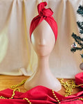 Santa Baby red wire head wrap styled with a twisted top knot on a mannequin, front view.